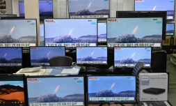 Des images d'un tir de missile nord-coréen sur des écrans dans une boutique de matériel informatique, le 25 mars 2021 à Séoul, en Corée du Sud
