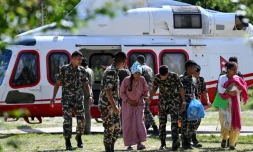 Des militaires soutiennent une rescapée, au camp de Trishuli, dans le district de Nuwakot au Népal, le 28 août 2026