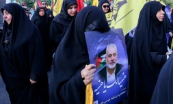 Une femme porte un portrait d'Ismaïl Haniyeh, lors d'une manifestation pour dénoncer sa mort, le 31 juillet 2024 sur la place de la Palestine à Téhéran