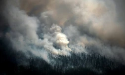 Vue aérienne prise depuis un avion le 27 juillet 2021, montrant la fumée s'élevant d'un feu de forêt à l'extérieur du village de Berdigestyakh, dans la république de Sakha, en Sibérie