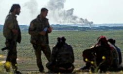 Une colonne de fumée s'élève dans le ciel du village de Baghouz, dans la province de Deir Ezzor (est), le 12 février 2019, durant l'offensive "finale" des Forces démocratiques syriennes (FDS) contre l'ultime réduit du groupe jihadiste Etat islamique (EI) en Syrie