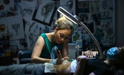 Ngoc Like réalise un tatouage sur le ventre d'une cliente dans son studio de Hanoï, le 20 mars 2021 au Vietnam