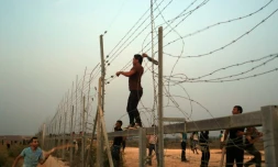 Des Palestiniens s'attaquent aux barbelés à la frontière entre Gaza et Israël, lors d'affrontements avec les forces de l'ordre israéliennes le 12 octobre 2015