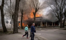 Des habitants courent dans une rue de Seveodonetsk aprÚs un bombardement russe qui a touché une maison en flammes, le 6 avril 2022 dans la région du Donbass, dans l'est de l'Ukraine