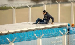 Un migrant est monté sur le toit d'un camion à Calais à l'entrée du tunnel sous la Manche pour pouvoir se rendre clandestinement en Grande-Bretagne, le 17 décembre 2015