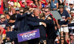 Donald Trump lĂšve le poing en l'air au moment d'ĂȘtre Ă©vacuĂ© de son meeting Ă Butler, aux Etats-Unis, le 13 juillet 2024