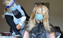 Kerry Clegg s'occupe des cheveux d'une cliente Ă Birkenhead (nord-ouest) le 4 juillet 2020