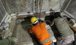 Des scientifiques replacent la plaque de marbre recouvrant la tombe que les chrétiens considèrent comme celle de Jésus dans l'église du Saint Sépulcre à Jérusalem, le 28 octobre 2016  