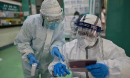 Des personnels médicaux vérifient des informations  des tests de Covid-19 qu'ils font passer aux habitants de Wuhan, le 16 avril 2020