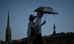 Des passants se protĂšgent du soleil avec un parapluie Ă Bordeaux, le 5 juillet 2026 en Gironde, lors d'une vague de chaleur en France