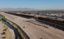 Des migrants attendent d'être pris en charge par la police aux frontières américaine près des rives du Rio Grande à Ciudad Juarez, au Mexique
