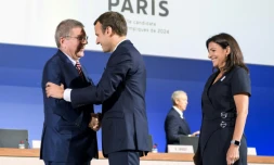 Le président Emmanuel Macron (c) serre la main du président du CIO à son arrivée au siège de l'instance à Lausanne pour la présentation de la candidature de Paris pour les JO-2024, le 11 juillet 2017  