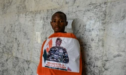 Un jeune homme porte un drapeau nigérien décoré avec le portrait du général Abdourahamane Tiani, chef des militaires qui ont pris le pouvoir au Niger, le 13 août 2023 à Niamey