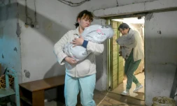 Des infirmiÚres transportent des bébés dans un le sous-sol d'une maternité pendant une alerte aérienne à Mykolaïv, en Ukraine, le 14 mars 2022