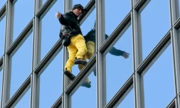 Le "Spiderman français", Alain Robert, escalade à mains nues la tour Total du quartier d'affaires de la Défense, le 21 mars 2016