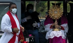 L'archevêque du Panama, José Domingo Ulloa (d) tient un ostensoir à bord d'un hélicoptère, le 5 avril 2020 à Panama 