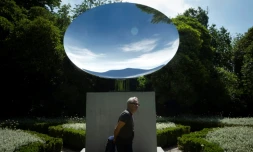 Le sculpteur britannique Anish Kapoor devant son oeuvre "Sky Mirror" lors de la présentation de l'exposition "Anish Kapoor: ?uvres, pensées, expériences", le 6 juillet 2018 dans le parc de la Fondation Serralves, à Port, au Portugal