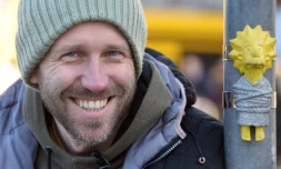 Mihaly Kolodko à coté d'une de ses petites statues "Lisa", un personnage des Simpsons, à Budapest, le 11 décembre 2019