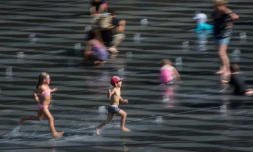 Des enfants jouent sur le Miroir d'Eau à Nantes, dans l'ouest de la France, le 24 juillet 2019