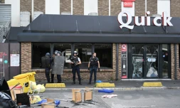 Des policiers devant un fast-food Quick aux vitres brisées pendant des émeutes, le 30 juin 2023 à Rosny-sous-Bois, en Seine-Saint-Denis