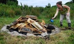 L'apicultrice Claire Prieur met le feu à son amas d'abeilles mortes et cadres de miel putréfiés, le 19 juin à Ploërdut (Morbihan).