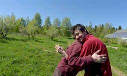 Svetlana, 35 ans, et Dima, 34 ans, se donnent l'accolade dans un champ de la ferme thérapeutique  près du village d'Aleksino (Russie), le 18 mai 2019
