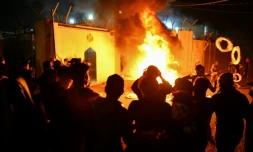 Des manifestants irakiens se rassemblent devant le consulat iranien dans la ville sainte chiite de Najaf, dans le sud de l'Irak, le 27 novembre 2019 alors que les flammes commencent à consumer le bâtiment