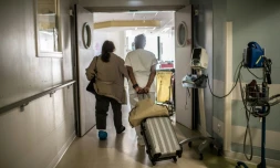 Aidée par une infirmière une patiente sort d'un hôpital parisien après y avoir été soignée contre la Covid-19, le 28 mai 2020