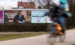Un homme à vélo passe devant une affiche électorale du président croate sortant et candidat à la présidentielle, Zoran Milanovic, à Zagreb, le 9 janvier 2025