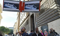 Un employé de la SNCM brandit des affiches des navires de la compagnie, le 25 septembre 2015 devant le palais de justice de Marseille