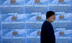 Un homme passe devant des affiches appelant à la grève générale le 9 mai 2024 à Buenos Aires, la deuxième depuis le début du mandat du président argentin Javier Milei