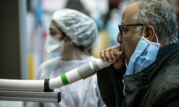 Un homme souffle dans un instrument en expérimentation qui doit permettre de dépister le virus du Covid-19, le 8 avril 2021, au Palais des sports de Lyon