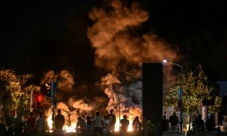Des passants regardent des pneus en feu sur une rue à Bordeaux, le 29 juin, 2023