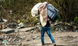 Un homme porte des couvertures pendant la démolition d'une partie du camp de la "jungle" de Calais, dans le Pas-de-Calais, le 3 mars 2016