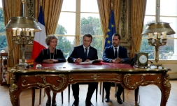 Le président Macron signe le 22 septembre 2017, entouré de Muriel Pénicaud, ministre du Travail, et de Christophe Castaner, ministre des Relations avec le Parlement, les ordonnances instaurant un barÚme des indemnités prud'homales