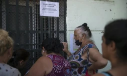 Des personnes attendent devant l'entrée de l'association "entre amis" à Séville, le 29 juin 2020