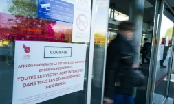 Une personne passe à côté d'une affiche sur les mesures à suivre pendant l'épidémie de Covid-19 à l'hôpital Emile Muller, le 8 mars 2020 à Mulhouse