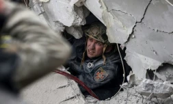 Un secouriste recherche des survivants dans un immeuble partiellement détruit par un bombardement russe, à Sloviansk en Ukraine le 14 avril 2023