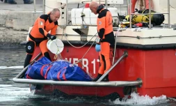 Retour au port italien de Porticello, en Sicile, des plongeurs recherchant les personnes portées disparues dans l'épave du yacht de luxe de Mike Lynch, un sac mortuaire à l’arrière du bateau, le 22 août 2024.