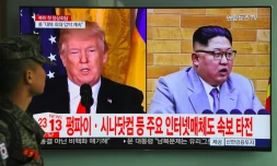 Un soldat sud-coréen regarde les portraits de Donald Trump et Kim Jong Un à la télévision, le 9 mars 2018