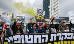 Des manifestants israéliens brandissent pancartes et banderoles devant le bureau du Premier ministre à Jérusalem, appelant à continuer de mettre en application l'accord de trêve à Gaza afin de ramener tous les otages encore captifs, le 11 février 2025

