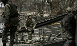 Des militaires ukrainiens se préparent à transporter le corps d'un camarade sur une civiÚre dans la ville d'Irpin, au nord-ouest de Kiev, le 13 mars 2022