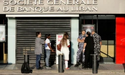 Des membres des forces de l'ordre contrôlant l'entrée d'une succursale d'une banque à Beyrouth, le 19 novembre 2019