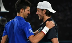 Le Serbe Novak Djokovic (g) congratule le Français Lucas Pouille, éliminé par le Croate en demi-finales de l'Open d'Australie, le 25 janvier 2019 à Melbourne  