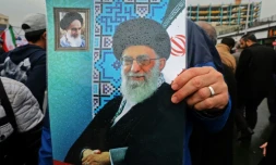 Un Iranien brandit une affiche avec le portrait du guide suprême Ali Khamenei (centre) et de l'ayatollah Rouhollah Khomeiny, père fondateur de la République islamique (en haut à gauche), lors du 40e anniversaire de la Révolution islamique à Téhéran, le 11 février 2019