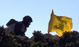 Photo fournie par le service de presse du Hezbollah en mai 2015 d'un combattant du Hezbollah érigeant le drapeau du mouvement en Syrie prÚs de Qalamun