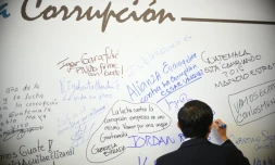 Un homme écrit sur un mur lors d'une journée de lutte anticorruption à Guatemala, le 9 décembre 2015