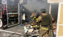 Photo prise et distribuée le 4 avril 2026 par le ministère des situations d'urgence ukrainien montrant des pompiers en train d'éteindre un incendie sur un marché après une frappe à Nikopol, dans le centre-est du pays