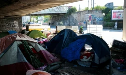 Un homme assis dans un camp de fortune de migrants sous une autoroute à la Porte de la Chapelle à Paris, le 19 avril 2017