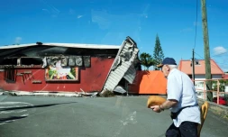Un homme passe devant un supermarché endommagé à Nouméa, en Nouvelle-Calédonie, le 24 mai 2024